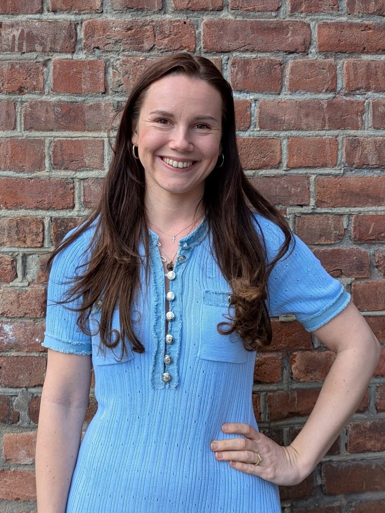 Kaja Yngsdal Hilleren smilende foran en murvegg